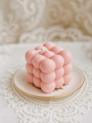 puderroza-sojas-vaska-bubble-svece Pūderrozā Bubble svece no sojas vaska uz dekoratīva šķīvja elegantā interjerā