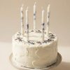 Dabīgā vaska kūkas svecītes ar ziedu dekoru uz baltas dzimšanas dienas tortes