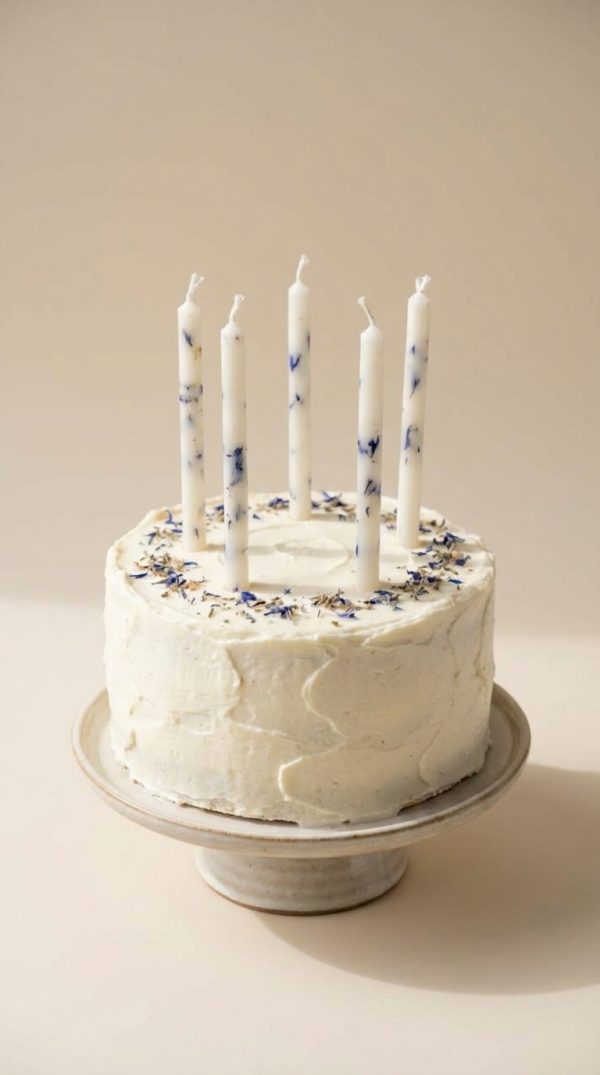 Dabīgā vaska kūkas svecītes ar ziedu dekoru uz baltas dzimšanas dienas tortes